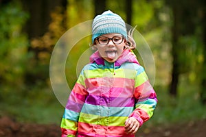 Little girl plays and runs in autumn park. The child walks in nature