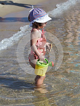 Little girl plays in the sea