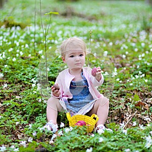 Little girl plays in spring forest at Easter