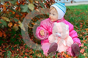 Little girl plays a toy bear