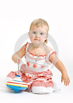 Little girl plays with toy on the white background