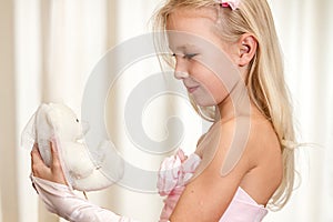 Little girl plays with wedding teddy-bear