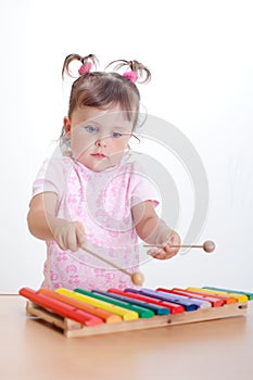 Little girl plays on xylophone