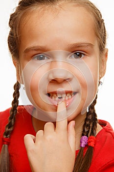 Little girl point by finger her first missing milk tooth, white background