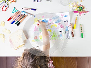 Little girl point at a sun in a kids drawing of multi-racial Family