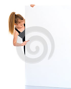 Little girl points a finger at a white banner.