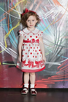 Little girl in a polka dot dress on background of