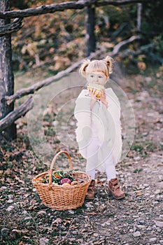 Little girl in a poncho eating yellow juicy pear