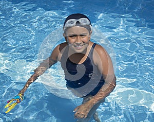 Little girl in pool with blue swimming.