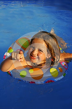 Little girl in pool pointing