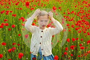 Little girl on the poppies meadow. Beautiful daughter on a poppy field outdoor. Poppies spring flowers.