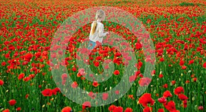 Little girl on the poppies meadow. Beautiful daughter on a poppy field outdoor. Spring flower blossom meadow background.