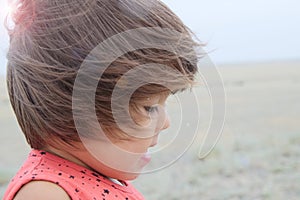 Little girl portrait happy smiling in big landscape environment. Child emotionally with expression outdoor