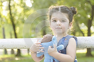 Little girl portrait holding a blue elephant doll in hands