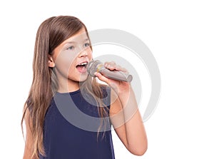 Little girl posing with a microphone for singing on white background.