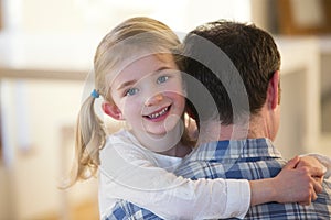 Little girl posing whilst being carried by her father