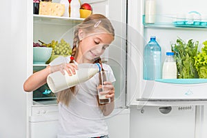 Little girl pouring milk in glass