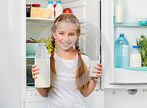 Little girl pouring milk in glass