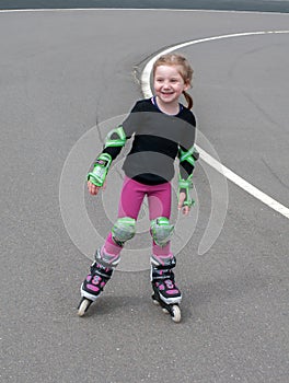 A little girl practicing roller skating at an otdoor skating rink photo