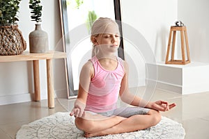 Little girl practicing yoga at home