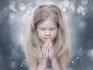 Little girl Praying with eyes closed.