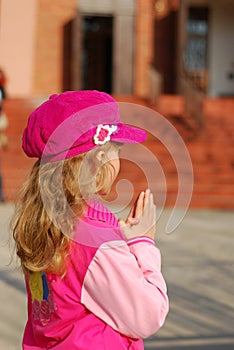 Little girl praying in front of church