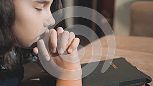 Little girl praying in the night. Little girl hand praying. little girl holy bible prays with bible in her hands. the