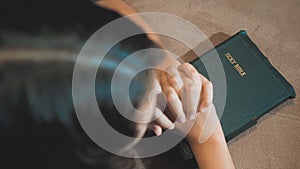 Little girl praying in the night. Little girl hand praying. little girl holy bible prays with bible in her hands. the