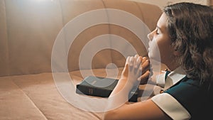Little girl praying in the night. Little girl hand praying. little girl holy bible prays with bible in her lifestyle