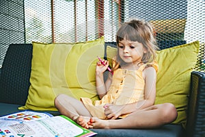 Little girl preschooler drawing in the study book