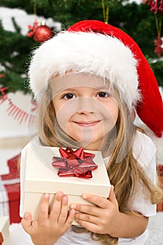 Little girl with present and christmas hat