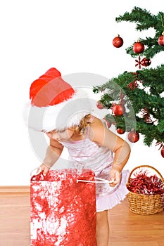 Little girl with present and christmas tree