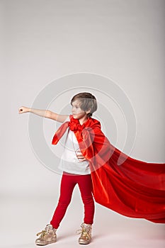 Little girl pretend superhero in red cape