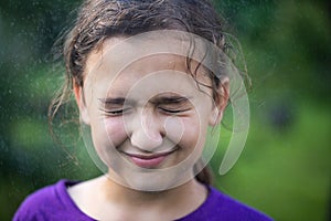 Little Girl With Pronounced Face From Or Warm Summer Rain In Park Outdoors