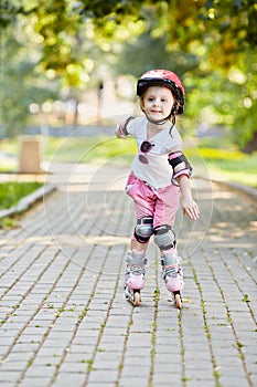 Little girl in protective equipment roller-skates