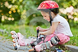 Little girl in protective equipment and rollers