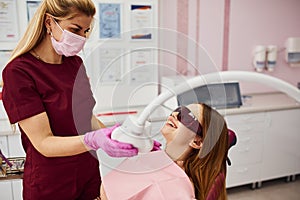 Little girl in protective glasses visiting dentist in clinic. Conception of stomatology