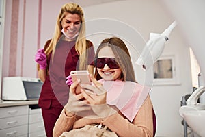 Little girl in protective glasses visiting dentist in clinic. Conception of stomatology