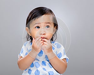 Little girl put finger into mouth
