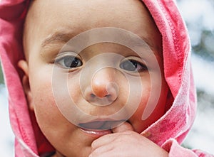 Little girl put finger into mouth