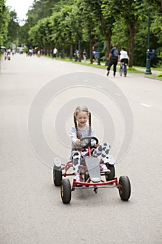 Little girl in racing car amusement park