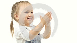 Little girl raises her hands up behind her head and plays. White background