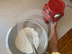 Little Girl Reaching for Sugar While Baking with Parents