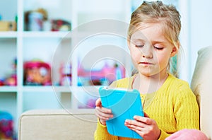 Little girl read book in tablet