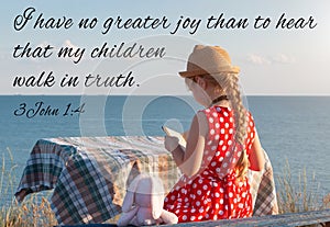 Little girl reading Bible on sea background. Quotes for believers. Inspirational Christian verse. Love people care faith