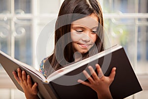 Little girl reading a big book