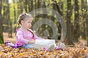 Little girl is reading a book