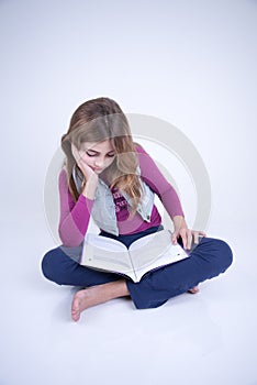 Little Girl reading a book sitting on the floor photo