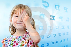 Little girl reading eye chart.