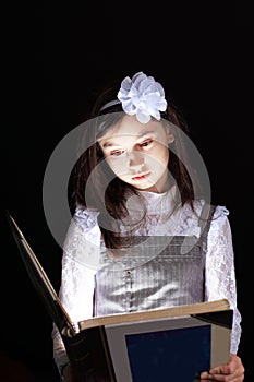 Little girl reading an interesting book.isolated on black background